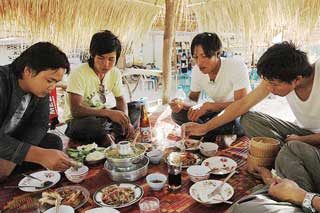 People enjoying authentic Thai food together sharing dishes family style meal