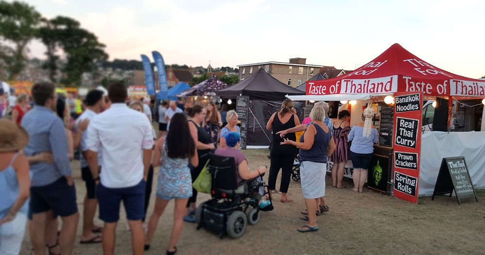 Large cooking setup at the Taste of Thailand Festival serving green curry to crowds