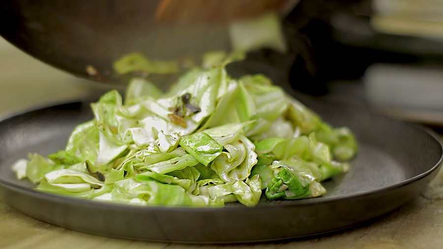 Sweetheart cabbage stir fry with golden garlic, crispy texture in a hot wok