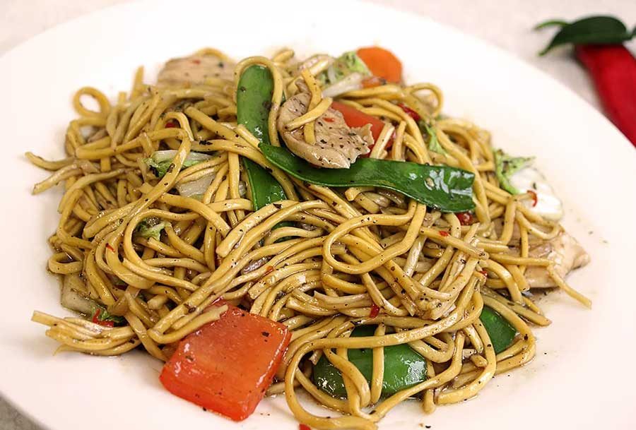 Chicken Bangkok noodles stir fried with vegetables and Thai soy sauce
