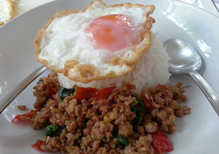 Classic pad krapow gai with crispy fried egg on top of Thai basil chicken