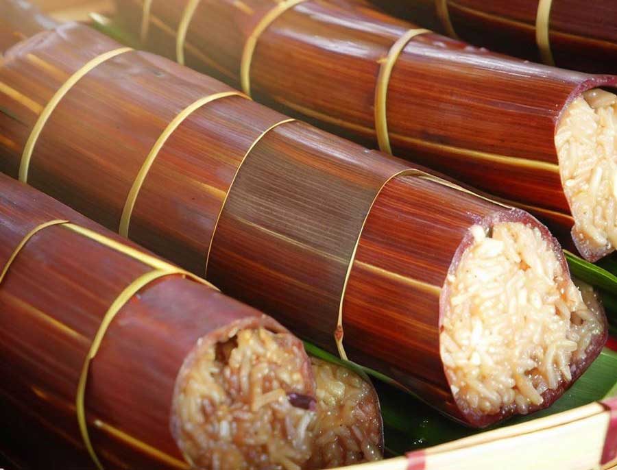 Khao Lam traditional Thai sticky rice cooked inside bamboo tubes served at street stalls